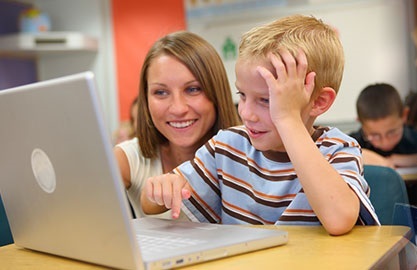 boy at laptop with woman watching